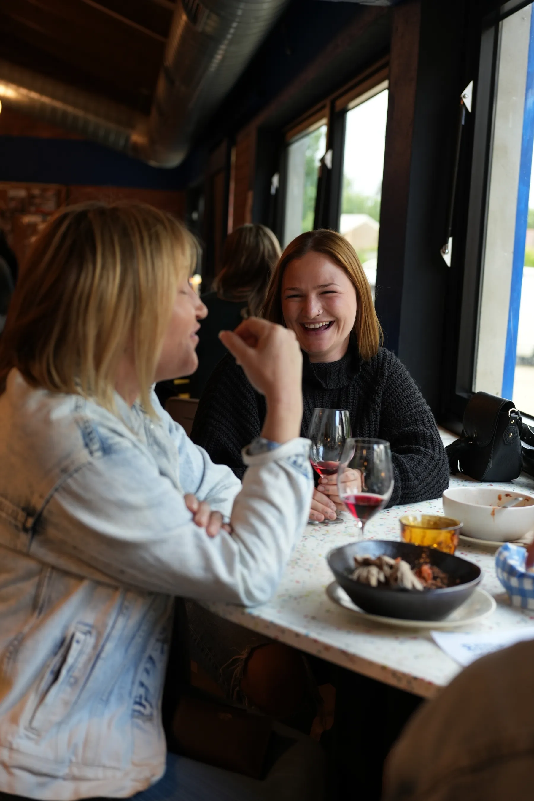 Friends laughing over a flight of wines at the Bottle Shock bar